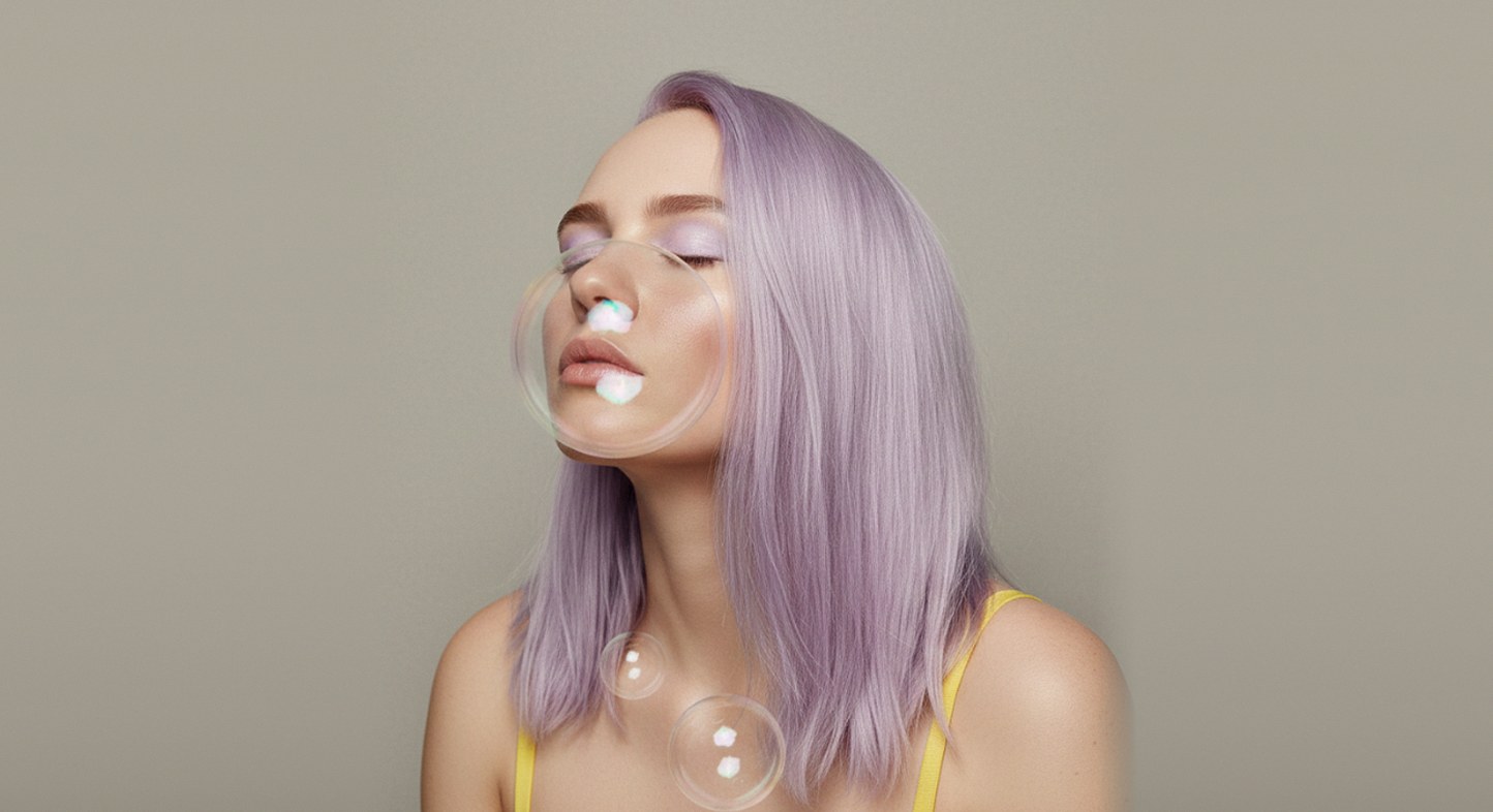 Portrait of a woman with lilac hair and soap bubbles